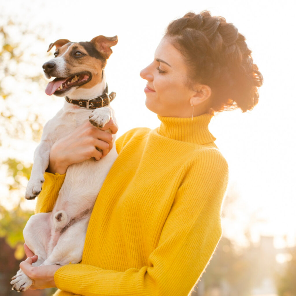 Junge Frau mit ihrem Terrier auf dem Arm
