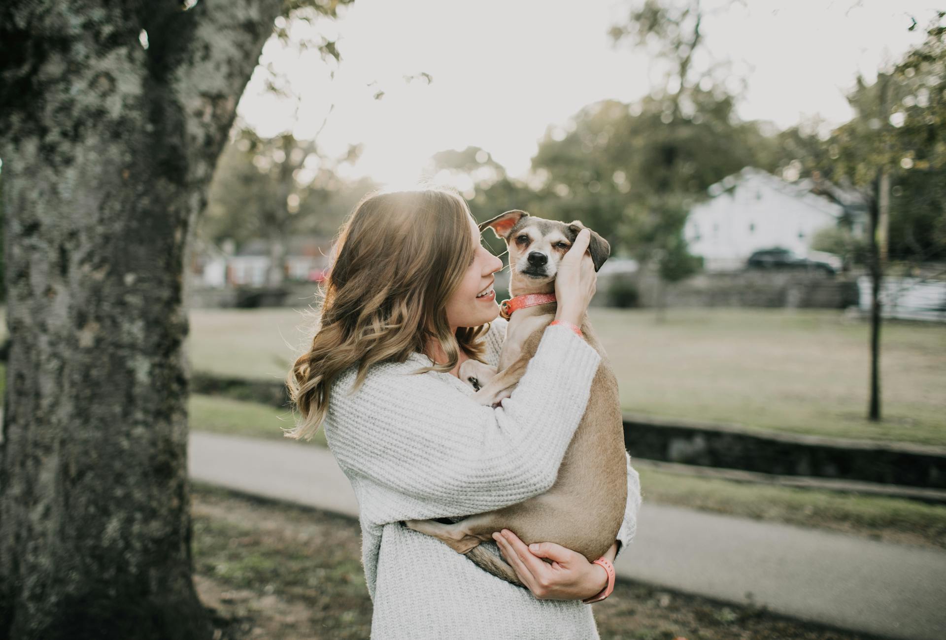 Eine junge Frau mit ihrem Hund auf dem Arm